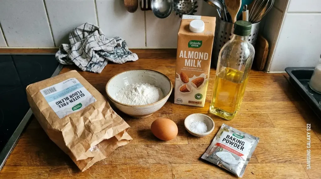 Składniki na naleśniki bezglutenowe — mąka bezglutenowa ryżowa jajko mleko olej na domowym blacie kuchennym
